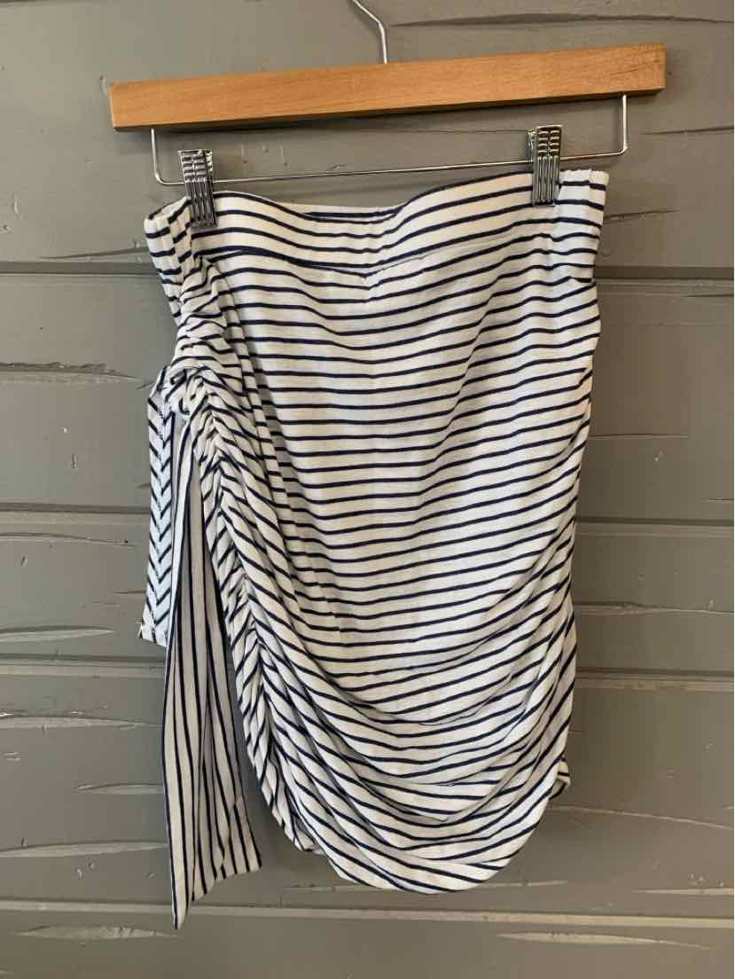 White mini skirt with black horizontal stripes and side ruched detailing hanging on wooden hanger.