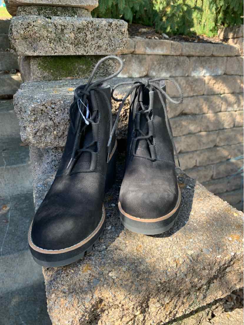 Pair of black leather lace-up ankle boots with rounded toes and tan-edged soles.