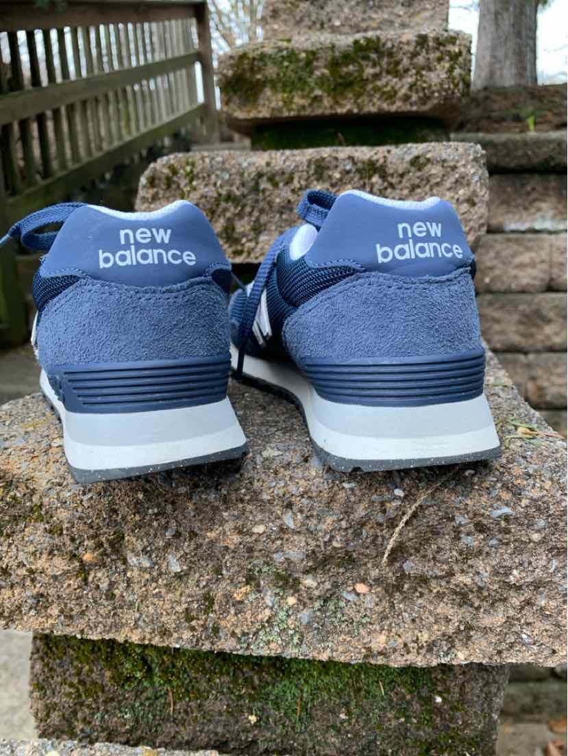 Pair of navy blue New Balance sneakers with white soles and "new balance" branding on the heel tab, size 7.