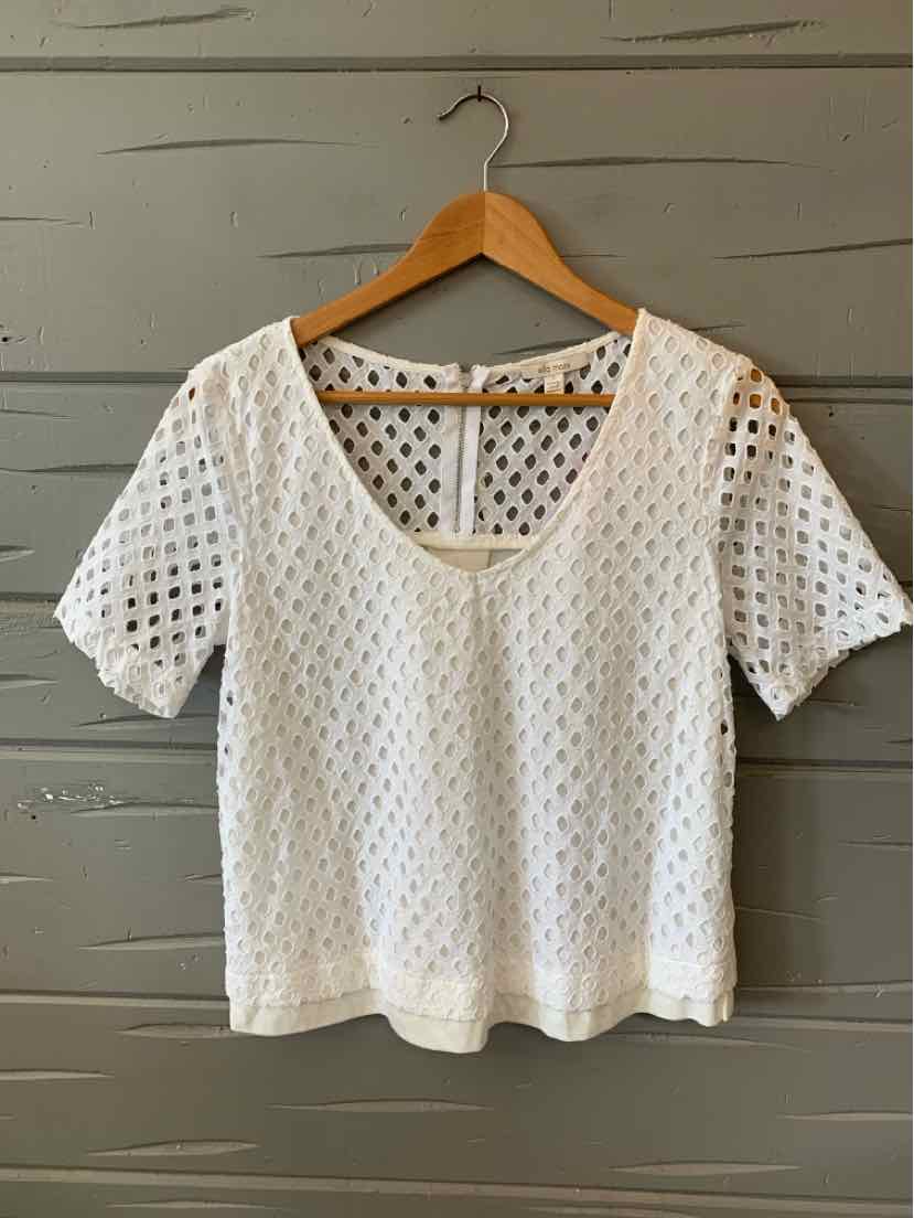 White short-sleeve mesh knit top with scoop neckline and scalloped hem on wooden hanger.