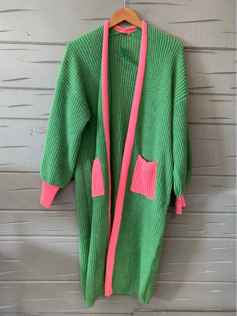 Long knit cardigan in green with pink trim along the opening, cuffs, and two front pockets, featuring a relaxed fit and.