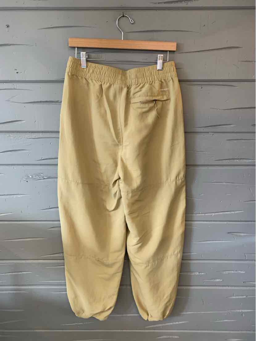 Tan relaxed-fit pants with elastic cuffs and waistband, single back zip pocket, lightweight fabric.