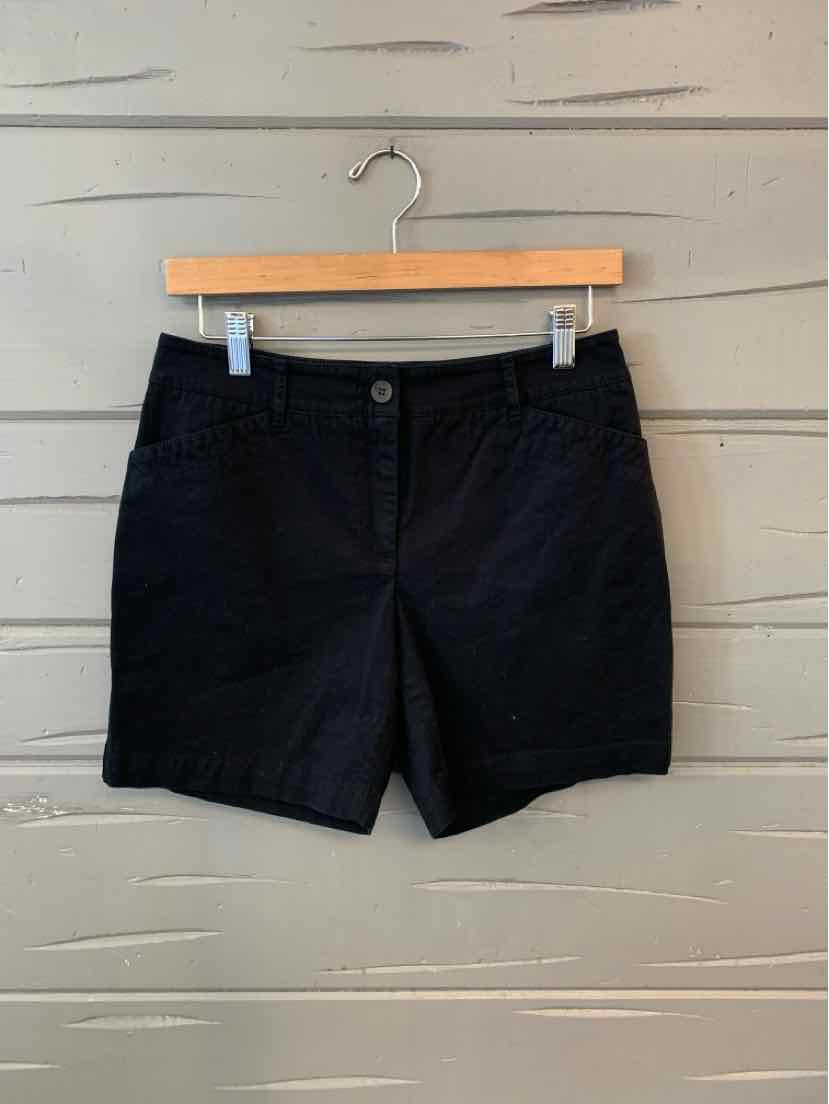 Black tailored shorts with front button and pockets, size 6P, hanging on wooden hanger.