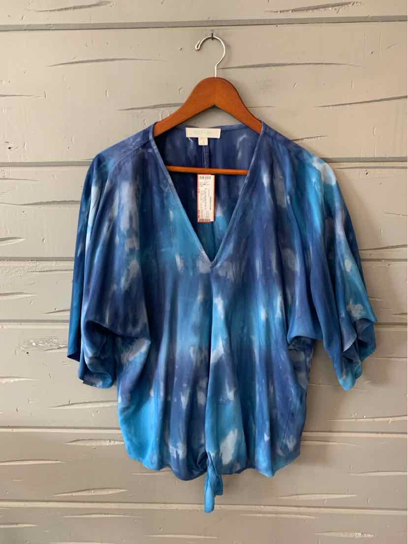 Blue tie-dyed blouse with loose short sleeves, V-neckline, and front tie detail on wooden hanger.