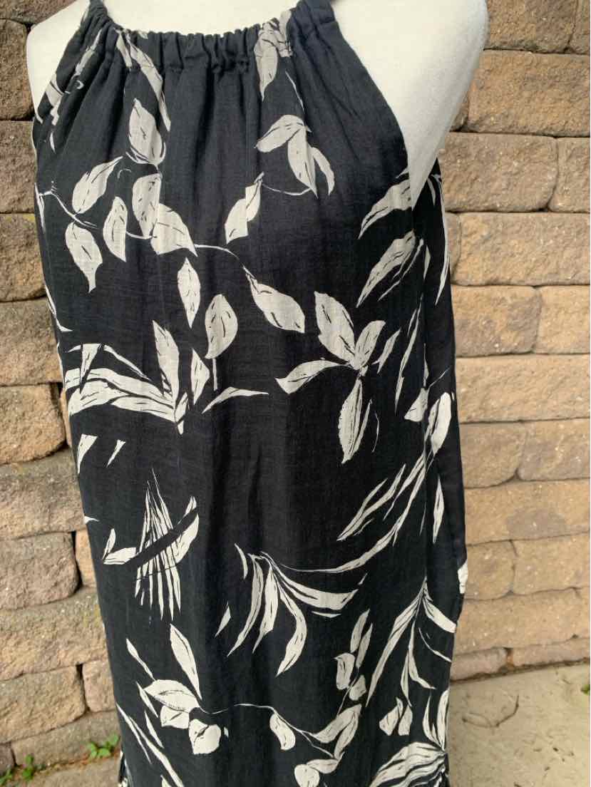 Black sleeveless dress with white floral print and gathered neckline.