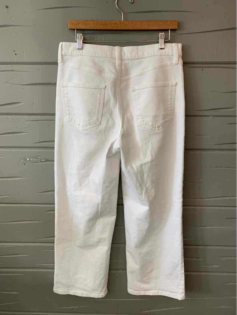 White denim wide-leg jeans with back pockets and belt loops, size 10, hanging on wooden hanger.