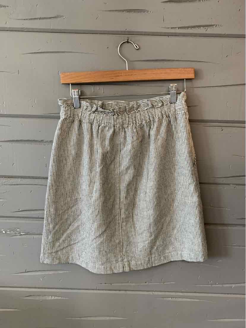 Light beige textured mini skirt with elastic waistband and subtle A-line shape.