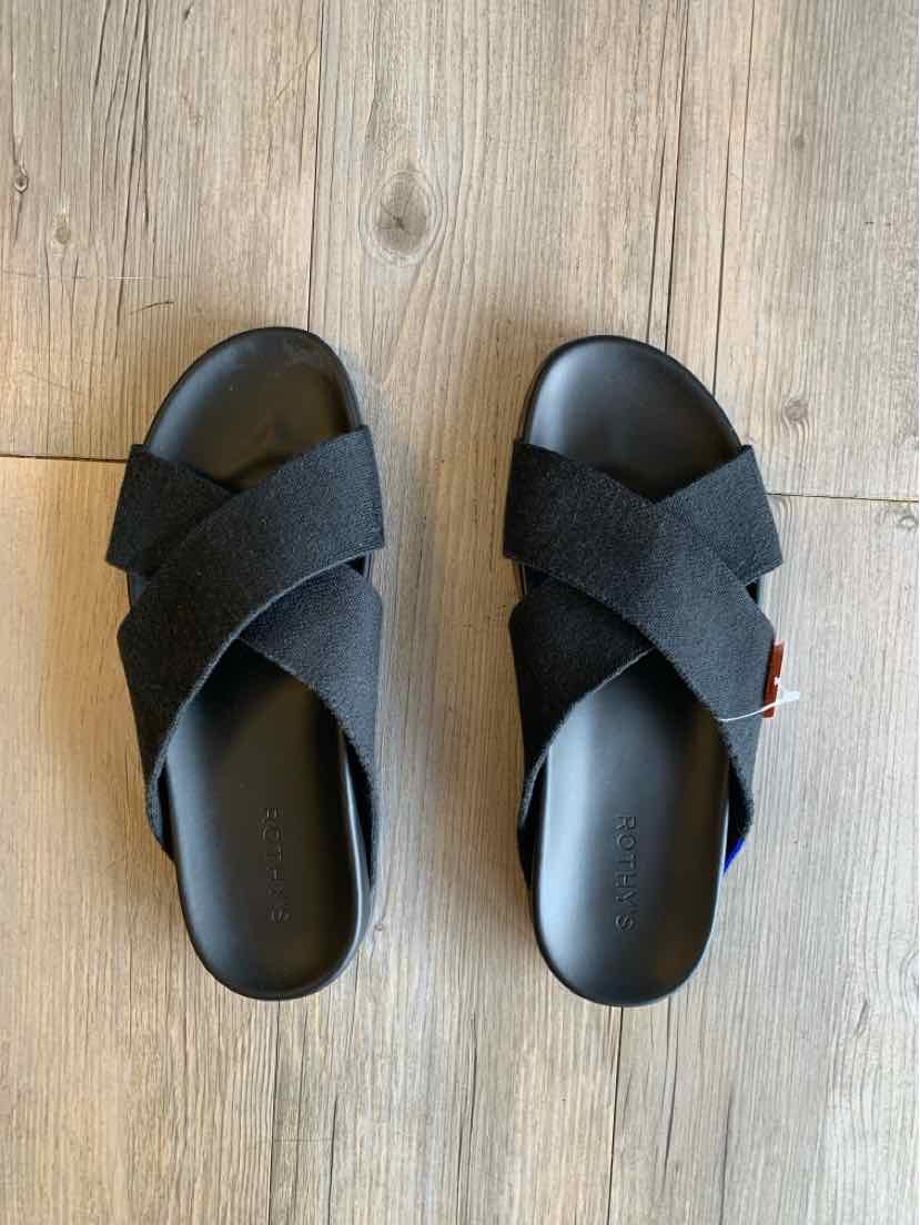 Black slip-on sandals with crossed fabric straps and cushioned soles, size 9.5.