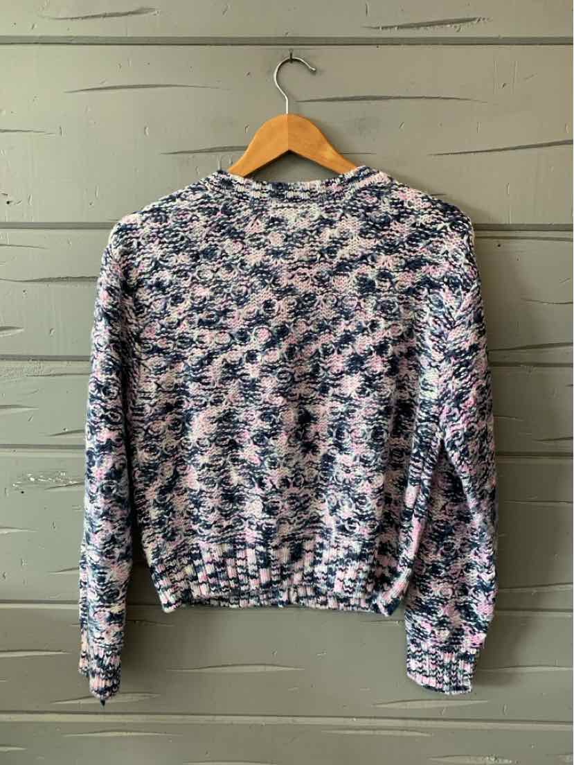 Long-sleeve knit sweater in pink and navy blue abstract pattern with crew neckline and ribbed cuffs.
