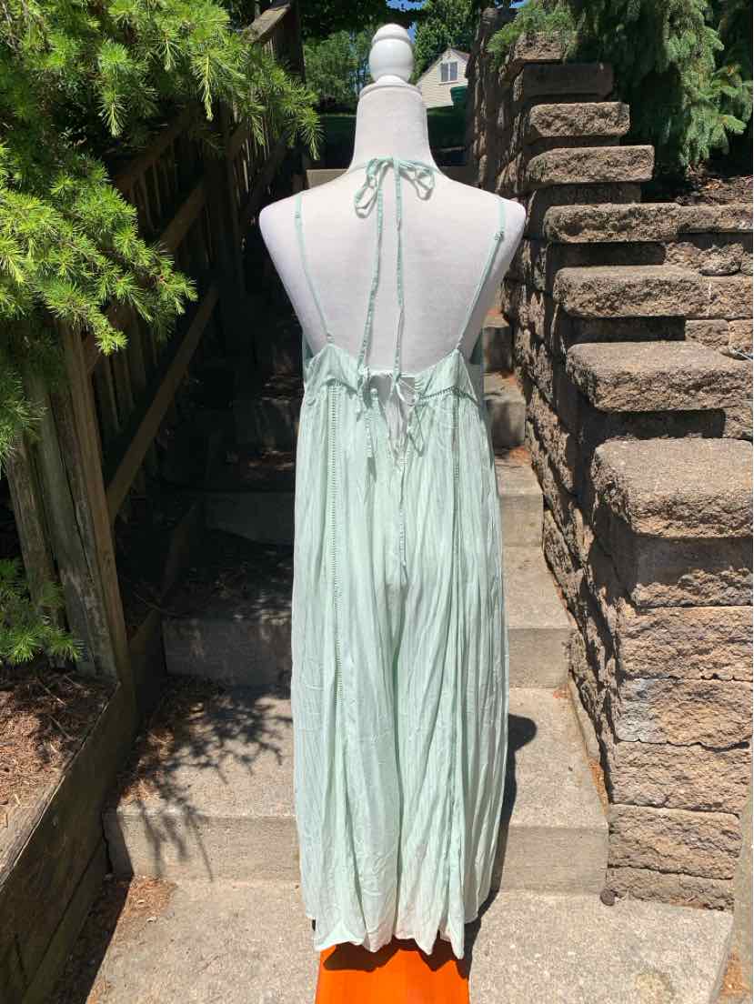 Mint green maxi dress with halter neck tie and pleated skirt detail.