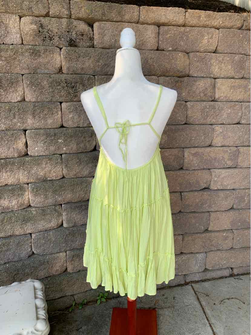 Light green sleeveless summer dress with thin straps and open back on white mannequin.