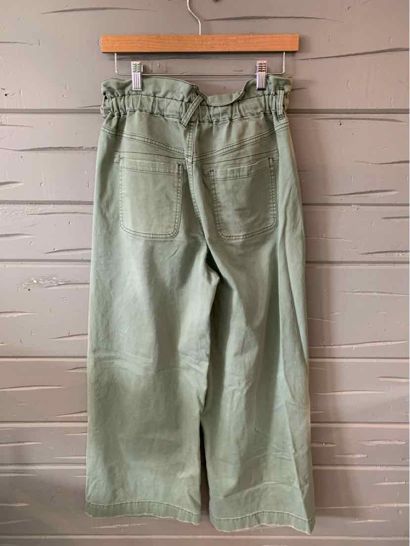 High-waisted olive green wide-leg pants with back patch pockets and a paperbag waist on a wooden hanger.