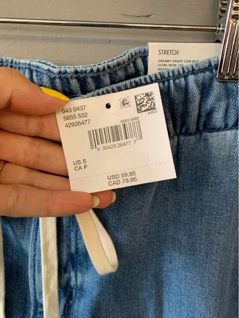 Blue denim jeans with elastic waistband and white drawstring, stretch fabric tag attached.