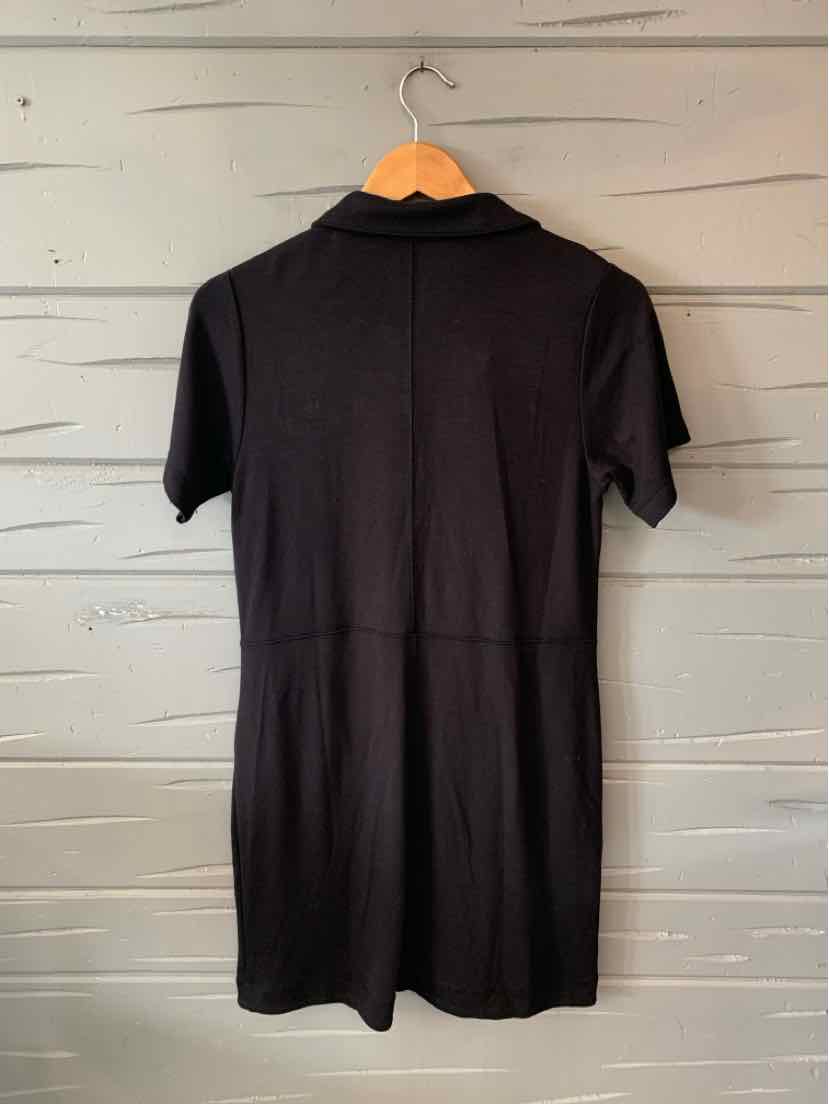 Black short-sleeve dress with collar, fitted waist, and knee-length hem hanging on wooden hanger.