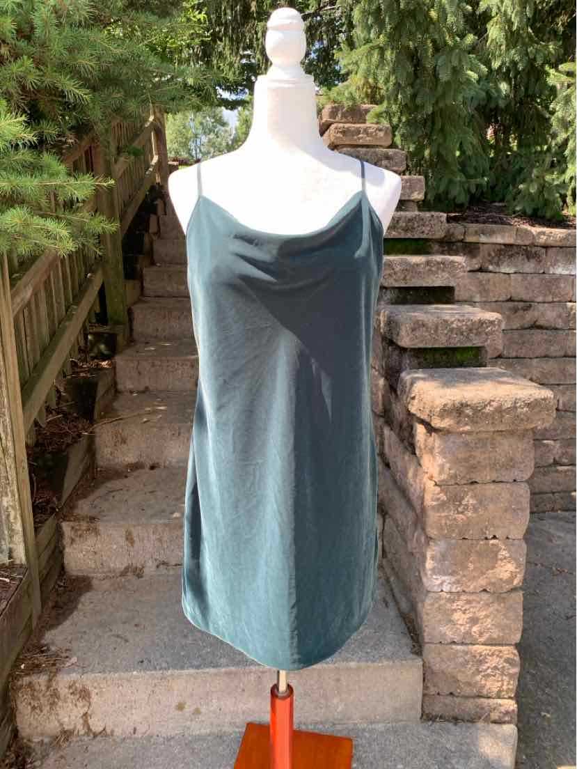 Green sleeveless dress with cowl neckline in lightweight fabric on a mannequin.