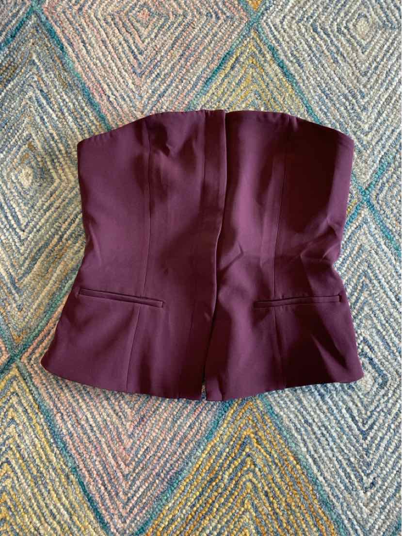 Deep burgundy strapless corset-style top with structured seams and front pockets.