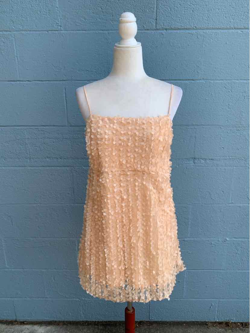 Peach sleeveless mini dress with textured floral appliqué and thin spaghetti straps.
