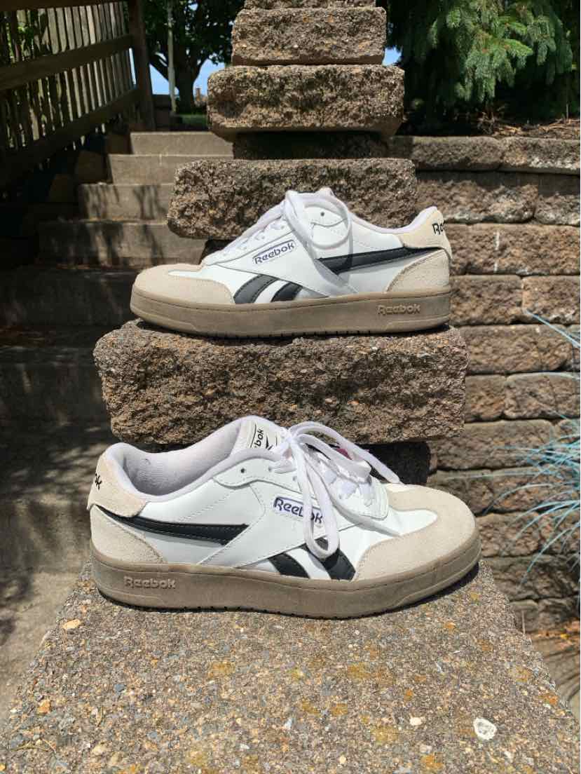 White Reebok sneaker with black and gray accents, suede toe cap, and lace-up closure in size 8.5.