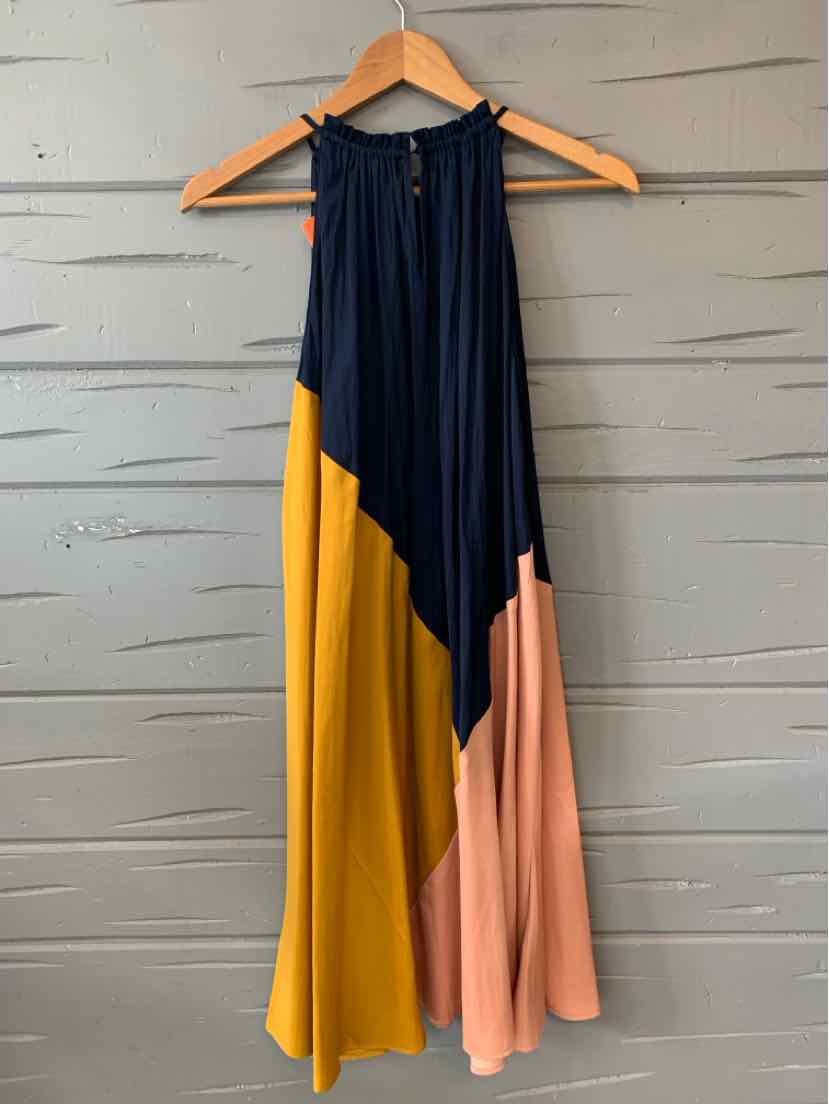 Sleeveless color block dress in navy, mustard yellow, and blush pink with a halter neckline and flowy silhouette.