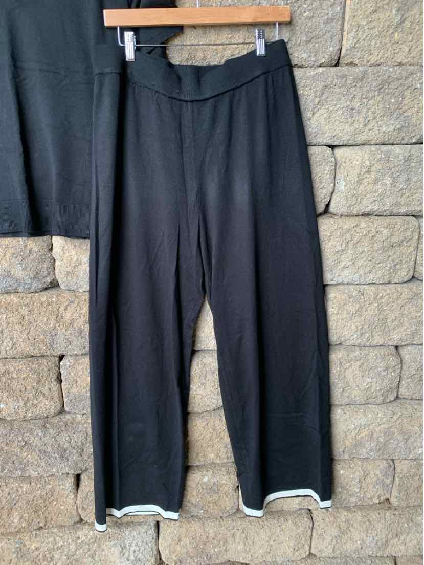 Black wide-leg pants with elastic waistband and white trim at the hem, part of a two-piece set.