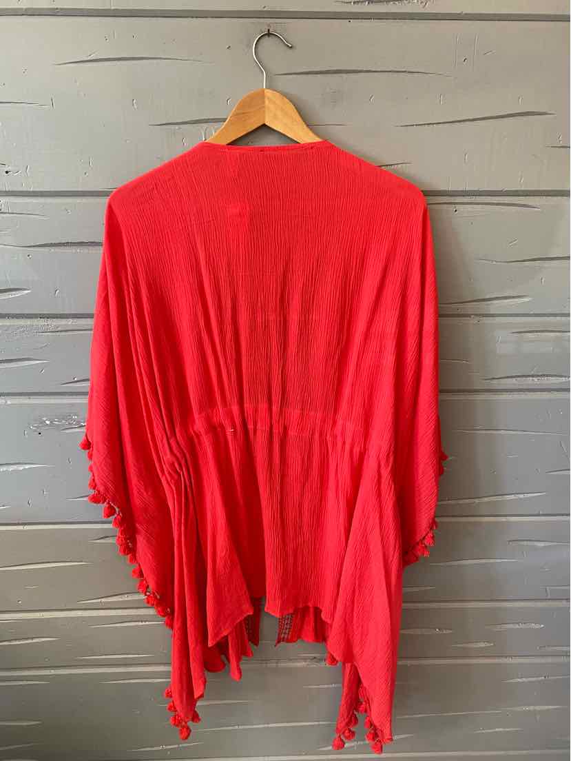 Bright red lightweight open-front cardigan with draped hem and flowy fit hanging on wooden hanger.