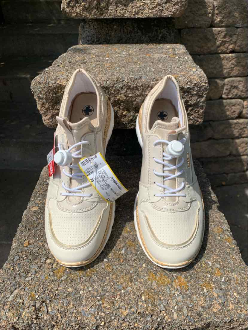 Beige sneaker with white laces, textured fabric, and cushioned sole, size 39.