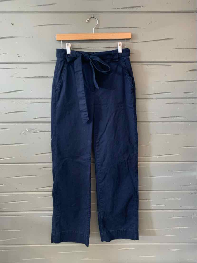 High-waisted navy blue wide-leg trousers with a fabric belt and front pleats.