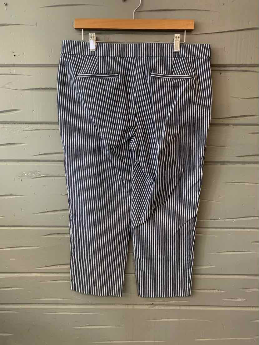 Blue and white striped cropped pants with back welt pockets and button details on a wooden hanger.