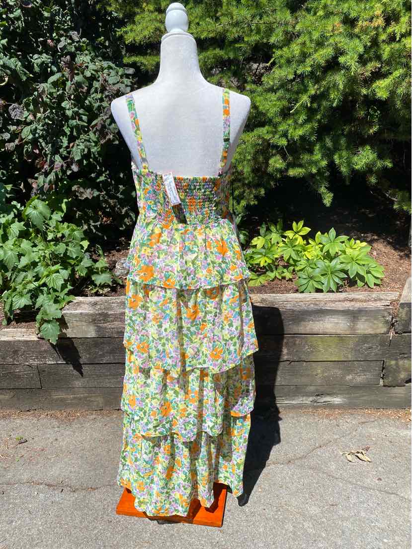 Large floral dress with tiered ruffles, adjustable spaghetti straps, and a smocked back panel in multicolor pattern.