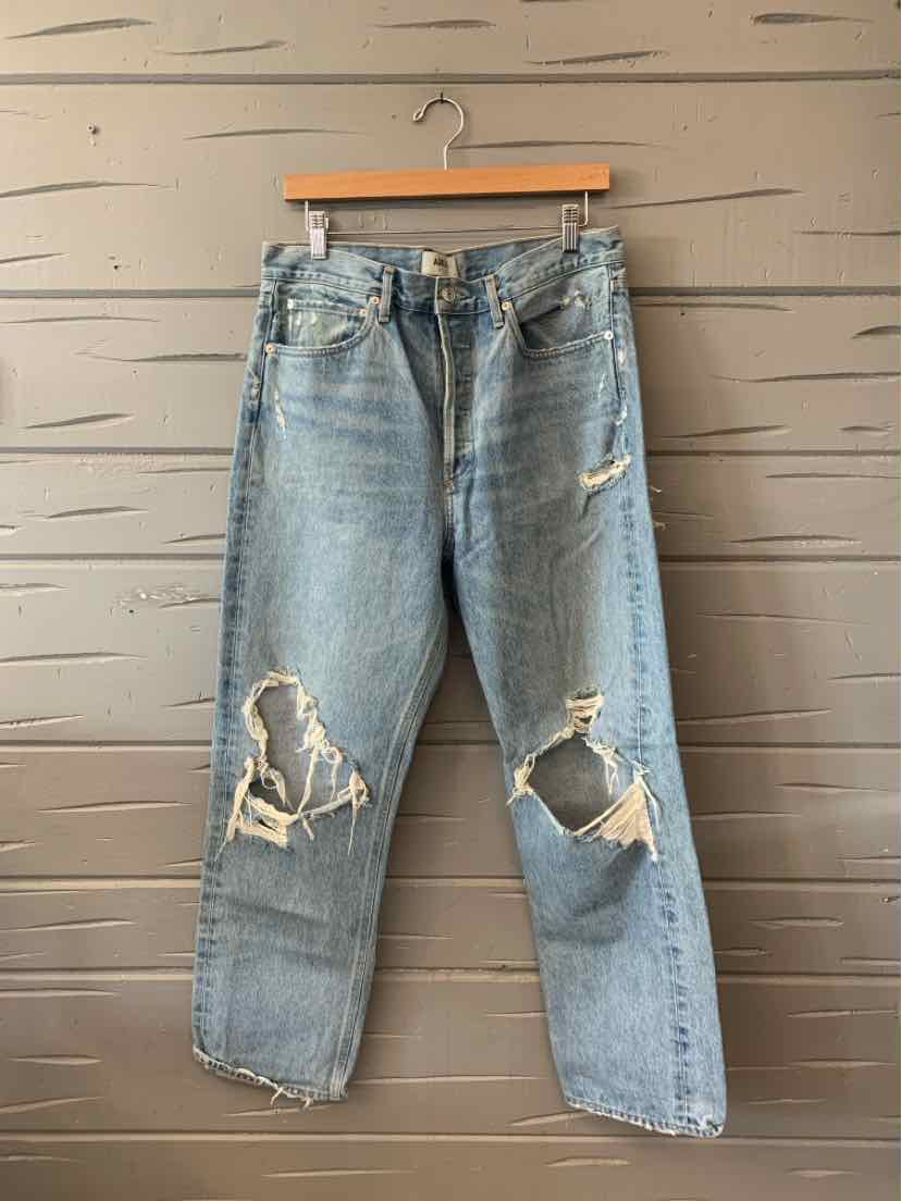 Light blue distressed denim jeans with large rips on both knees, straight-leg fit.