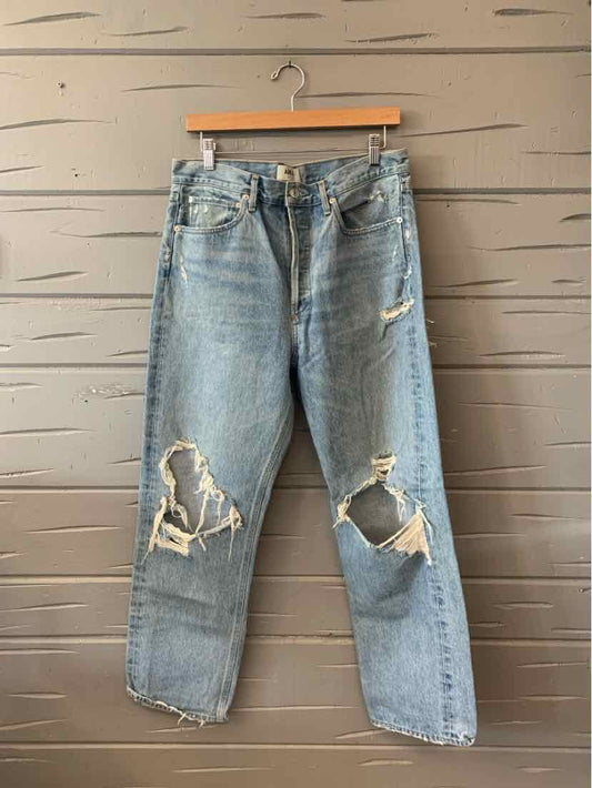 Light blue distressed denim jeans with large rips on both knees, straight-leg fit.