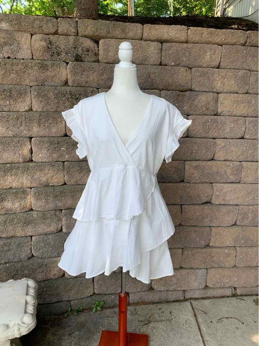 White short-sleeve tiered mini dress with V-neck and flutter sleeves on mannequin.