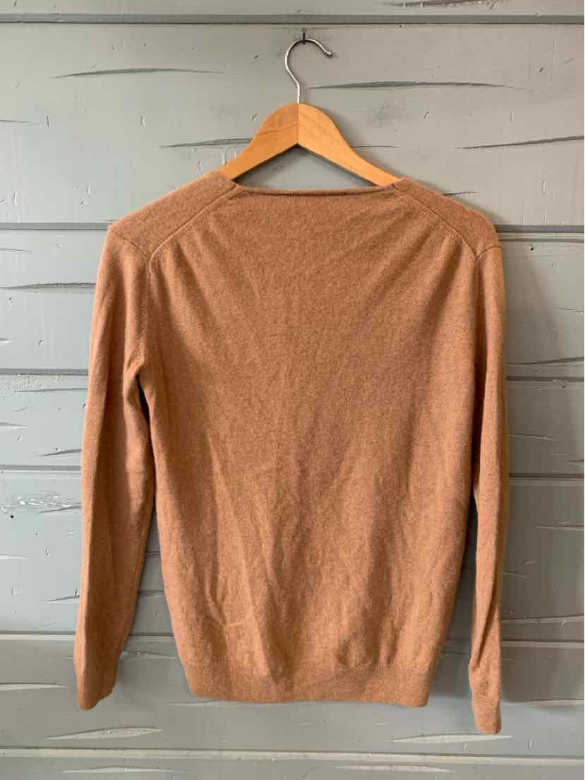 Tan lightweight knit sweater with long sleeves and a crew neckline on a wooden hanger.