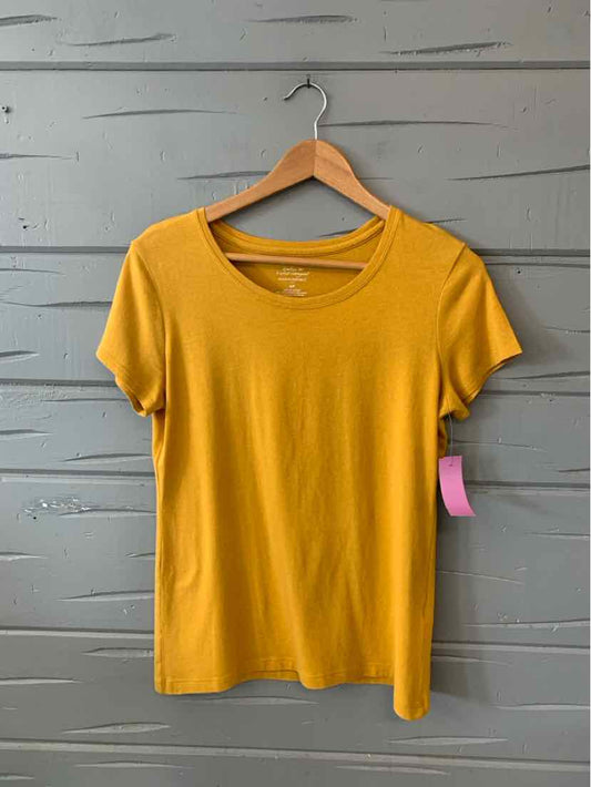 Yellow short-sleeve crew neck women's t-shirt on wooden hanger against gray wood panel background.
