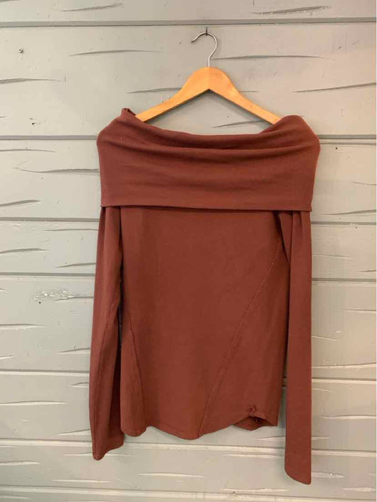 Brown off-the-shoulder long-sleeve top with wide folded neckline on wooden hanger.