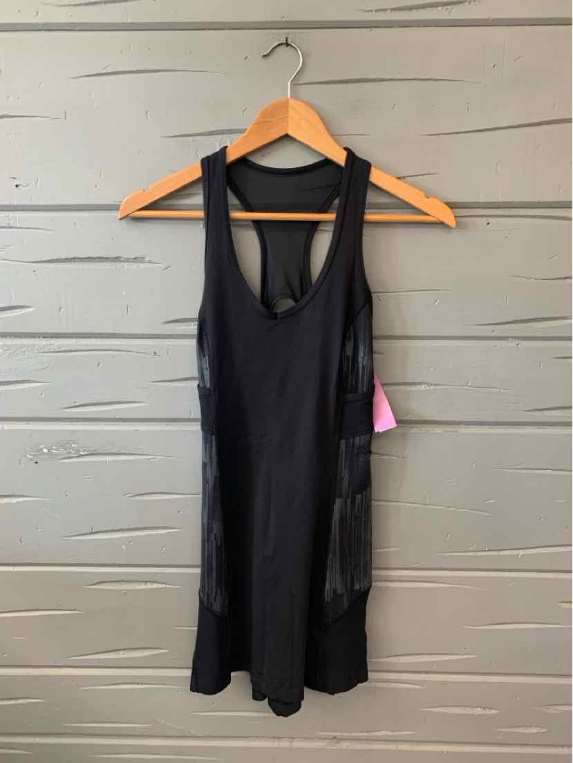 Black sleeveless athletic tank top with racerback and built-in sports bra hanging on wooden hanger.