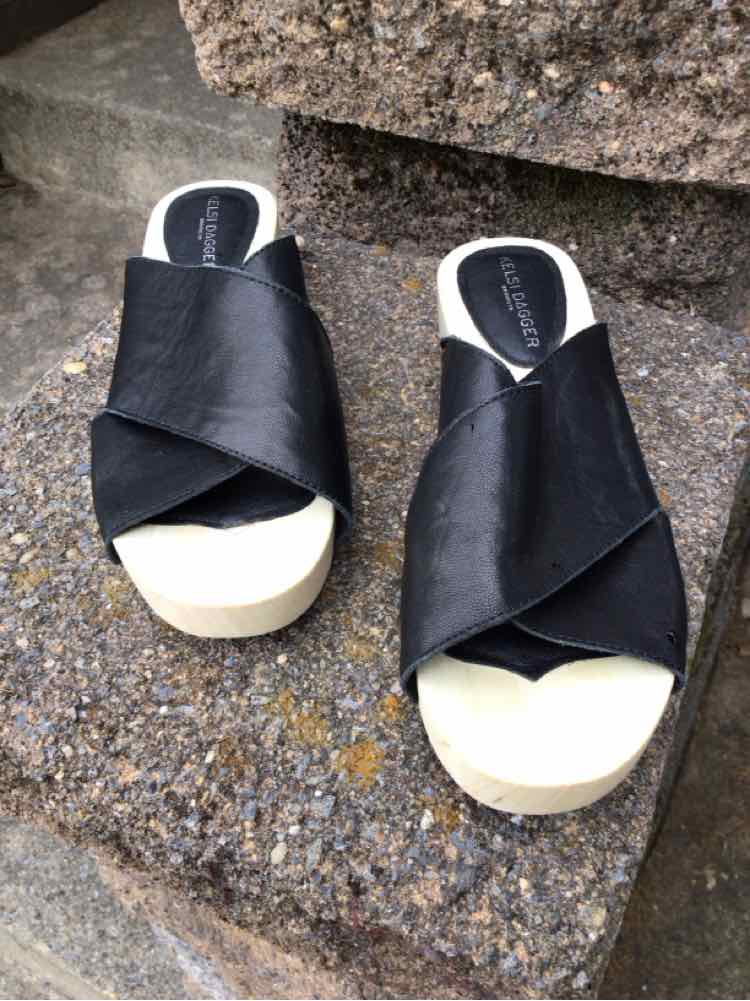Black leather crisscross strap sandals with white soles, size 6.5.