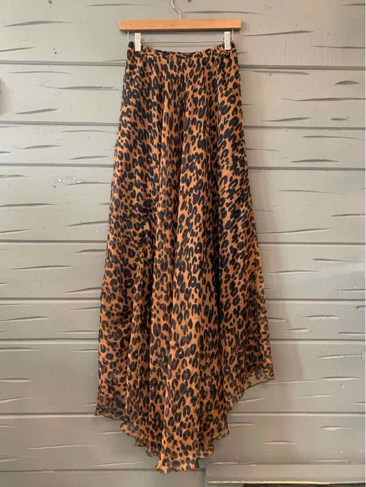 Brown and black cheetah print flowy midi skirt with asymmetrical hem on wooden hanger.