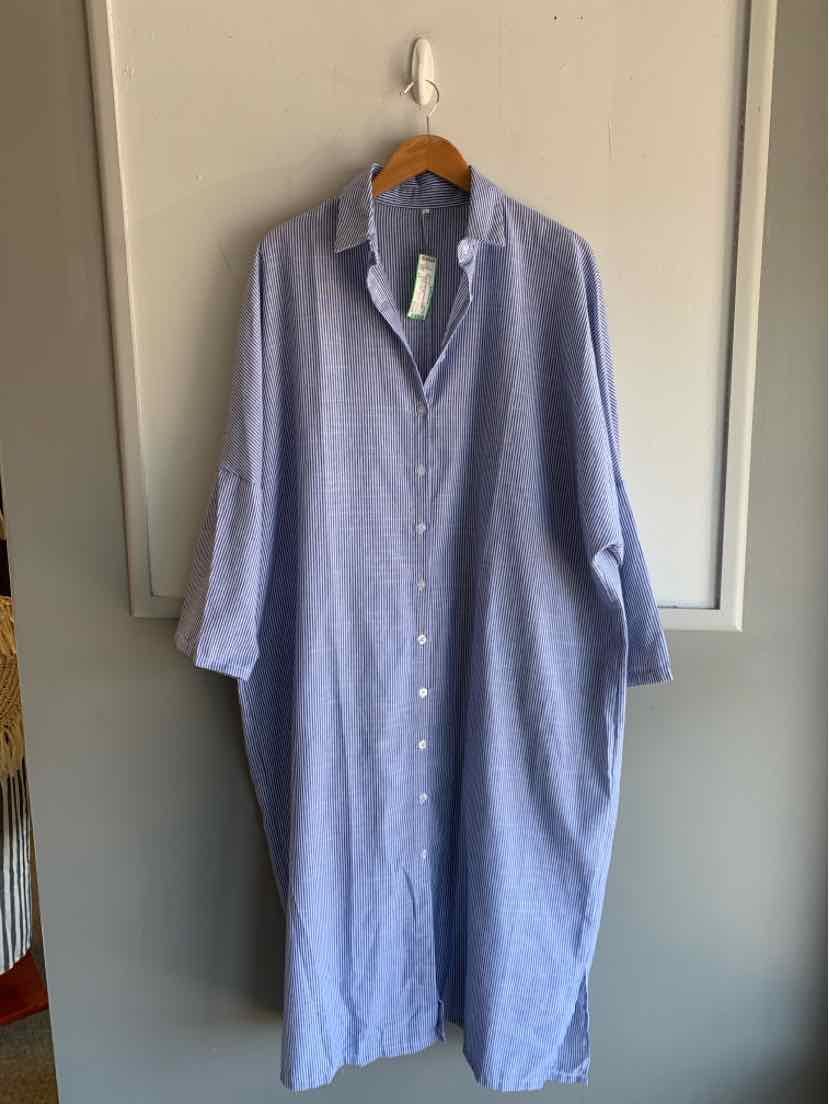 Light blue button-up long dress with white vertical stripes and a relaxed fit hanging on a wooden hanger.
