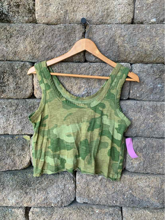 Green camo cropped tank top with scoop neck and wide shoulder straps on wooden hanger.