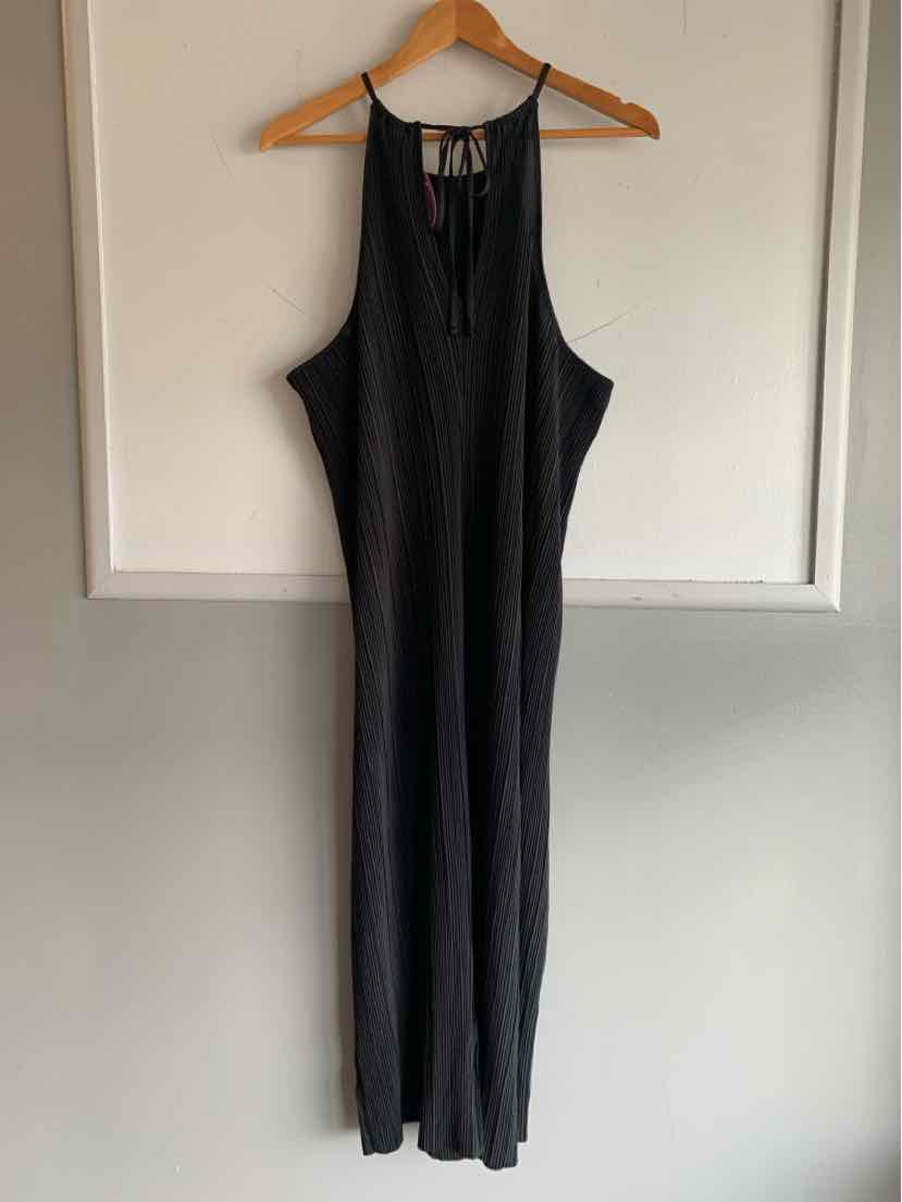 Black sleeveless jumpsuit with slim fit and wide legs, size XL, hanging on wooden hanger.