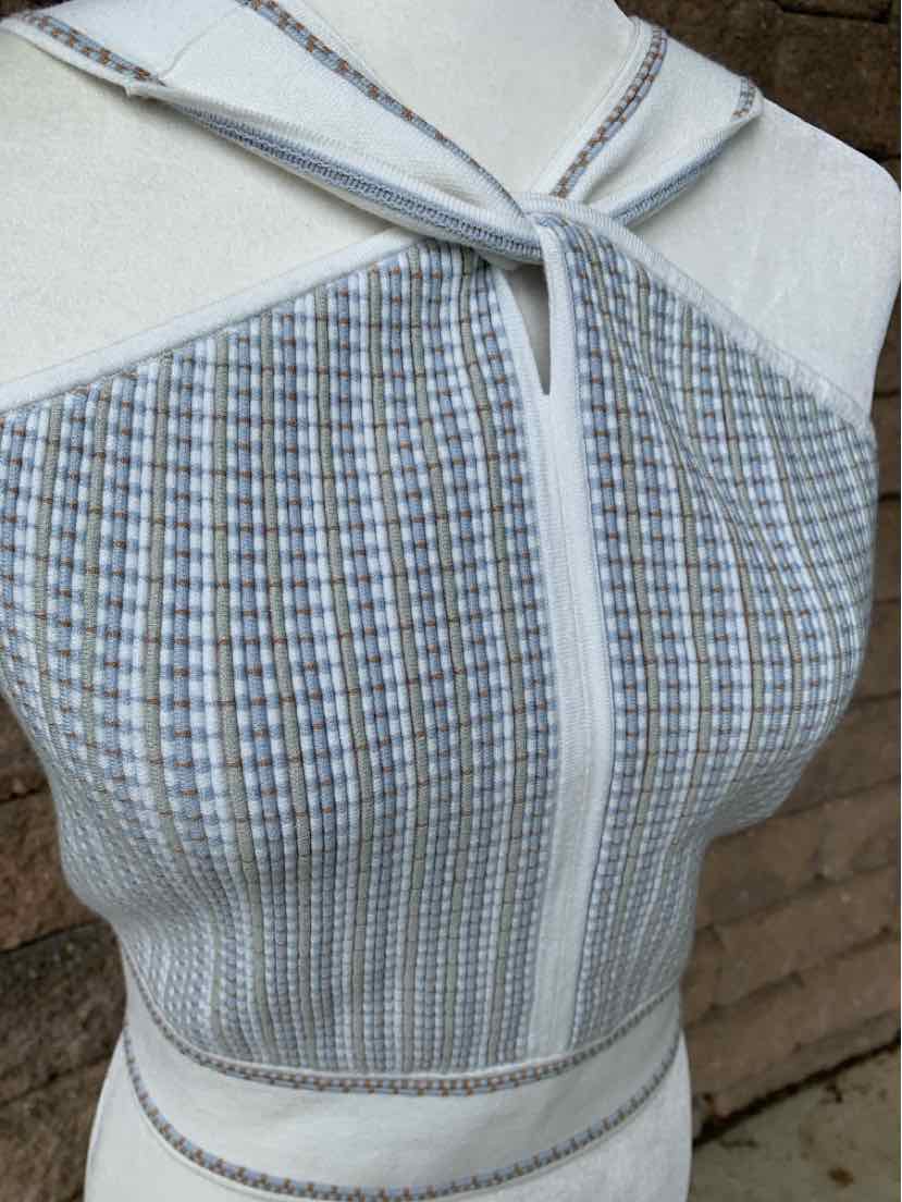 Sleeveless knit top in blue and white check pattern with front zipper and fitted silhouette.