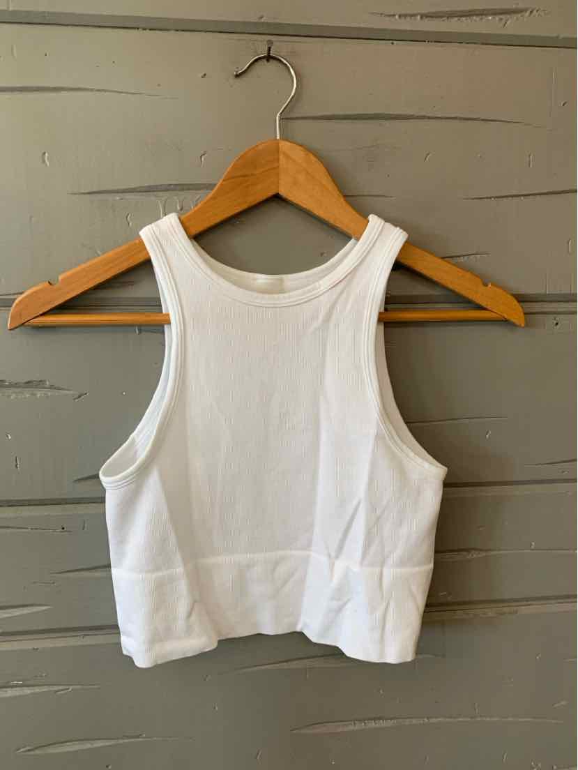 White cropped tank top with wide shoulder straps and a racerback design on a wooden hanger.