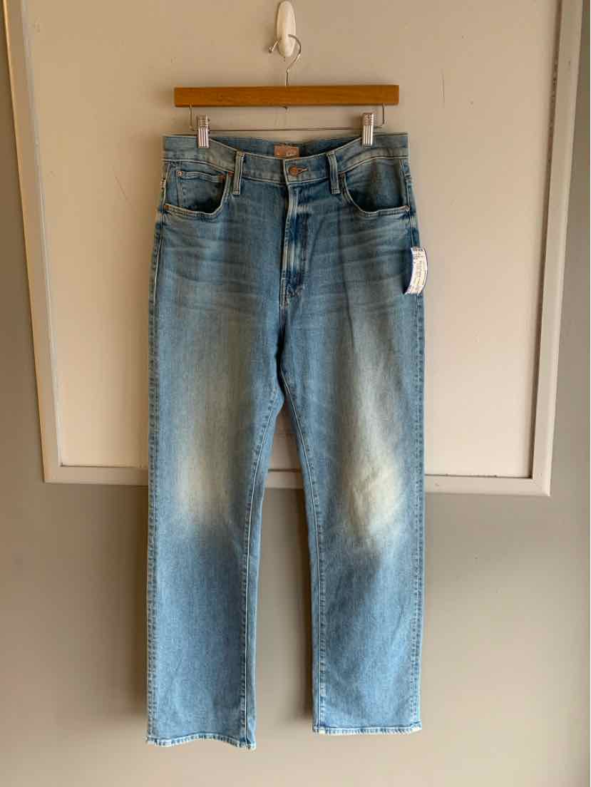 Light blue high-waisted denim jeans with straight legs and front button fly hanging on wooden hanger.