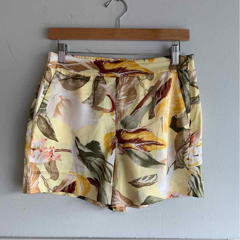 Yellow tropical print women's shorts with elastic waistband and side pockets.