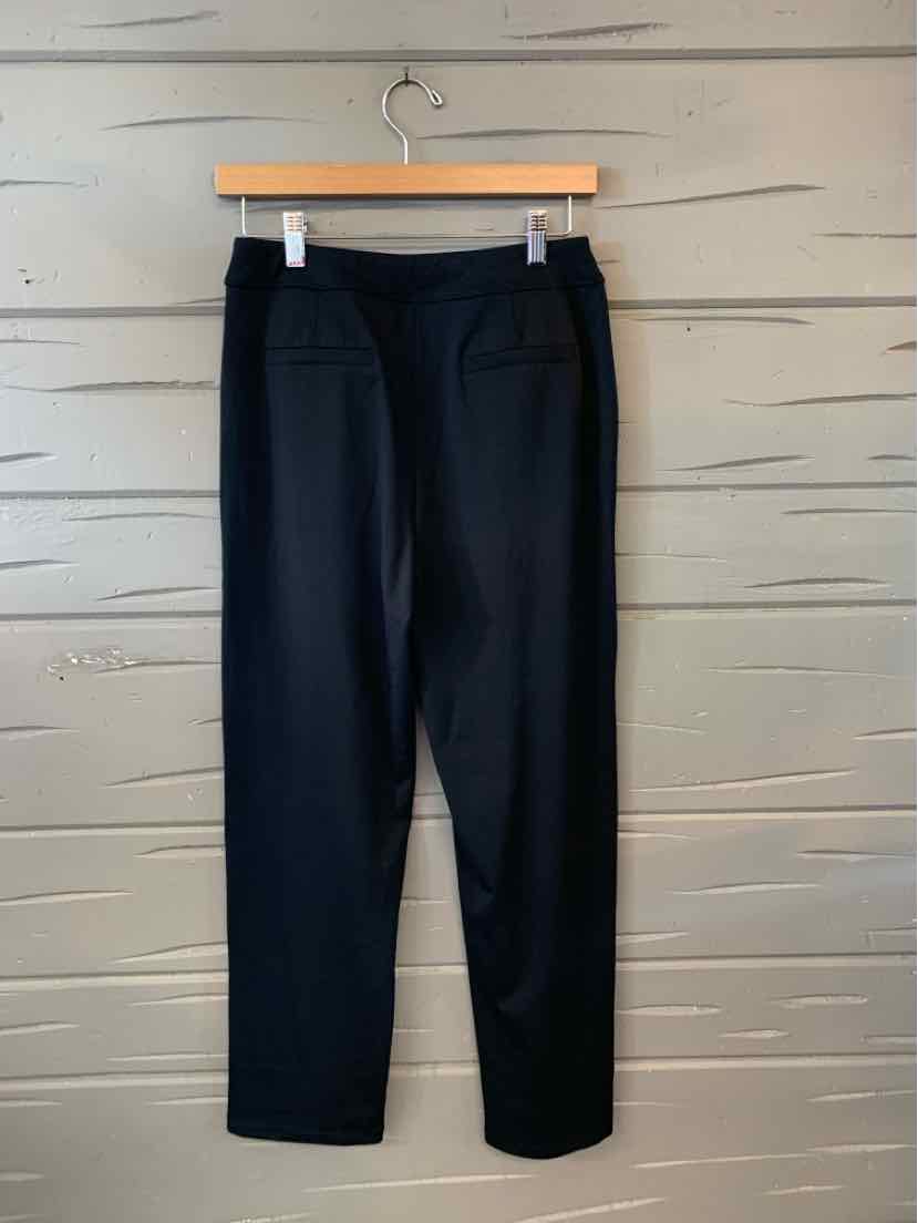 Black slim-fit pants with a mid-rise waist and two rear welt pockets, displayed on a wooden hanger.