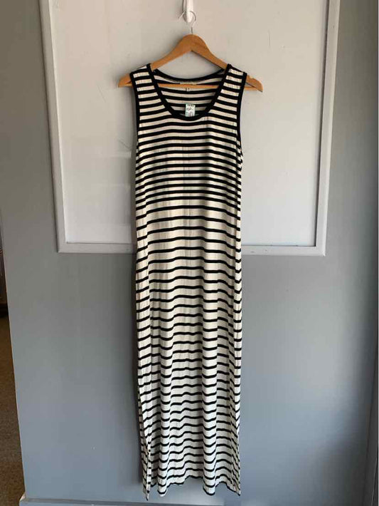 Black and white striped sleeveless maxi dress with scoop neckline hanging on wooden hanger.