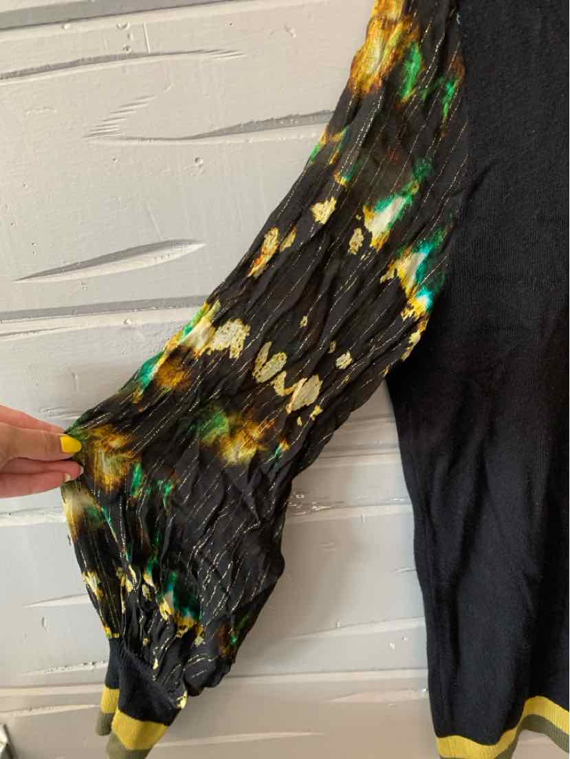 Black long-sleeve garment with a puffed sleeve featuring green, yellow, and cream abstract patterns on sheer fabric.