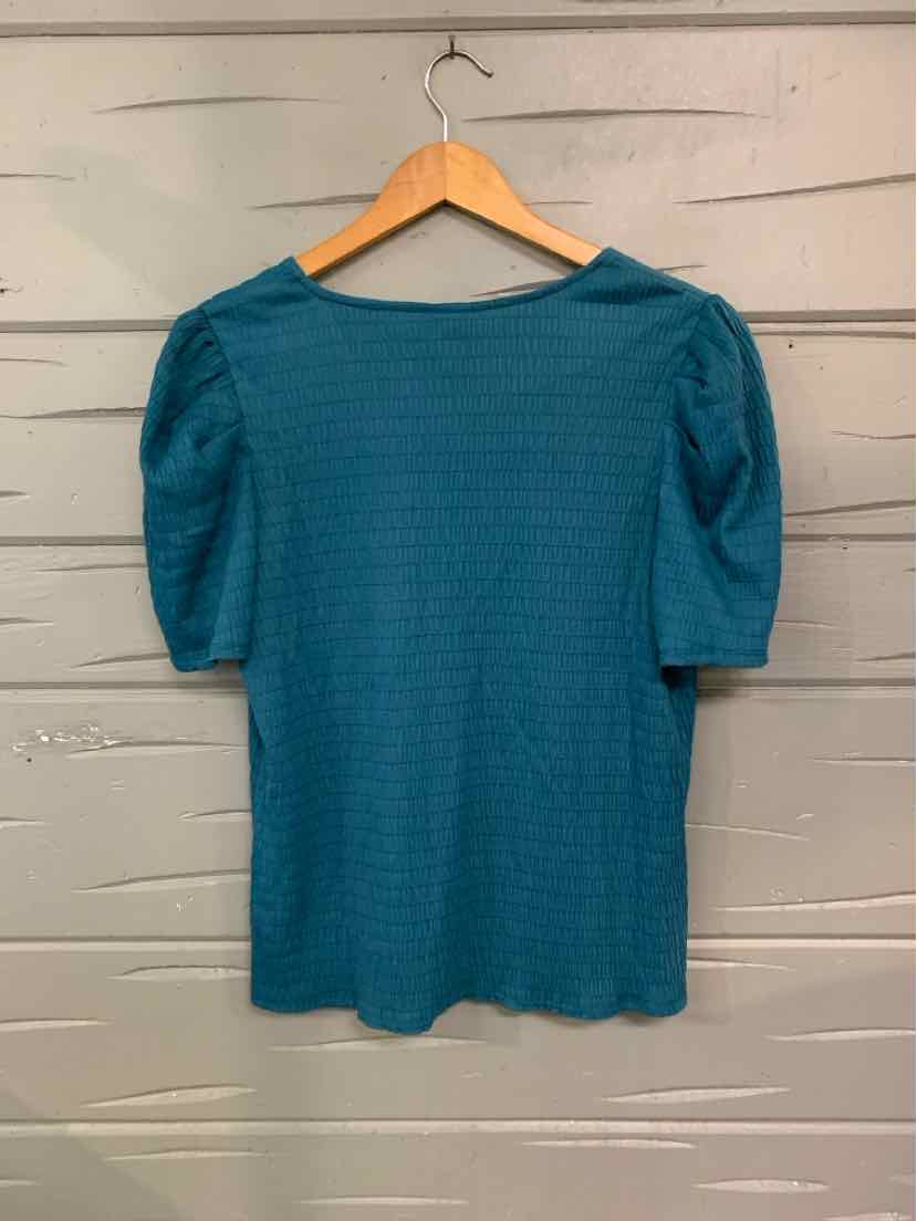 Teal short-sleeve blouse with puffed shoulders and textured fabric hanging on wooden hanger.