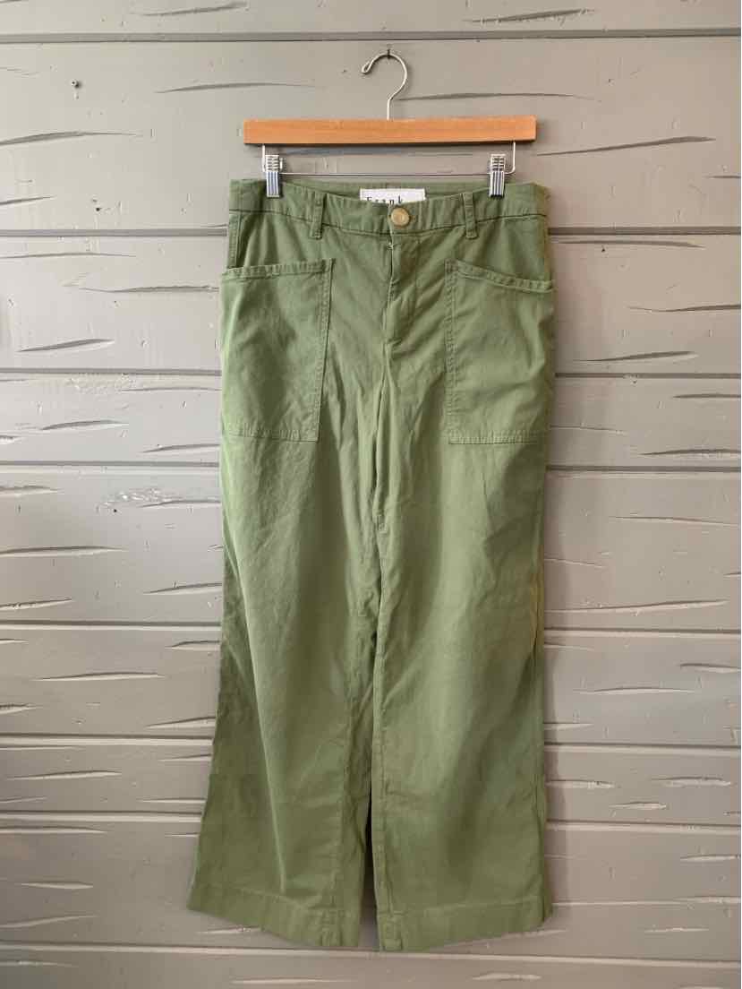 Olive green high-waist pants with wide legs and front pockets on wooden hanger.